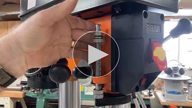 A twelve-inch benchtop drill press sits on a wooden workbench.